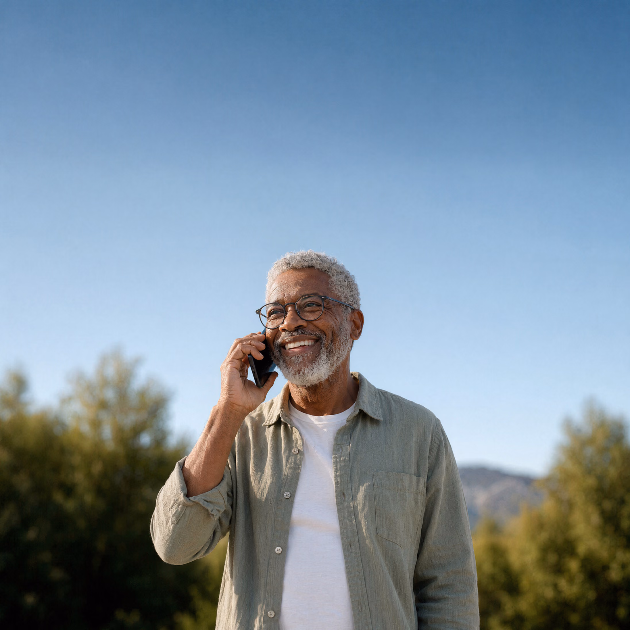 Smiling homeowner on the phone outdoors