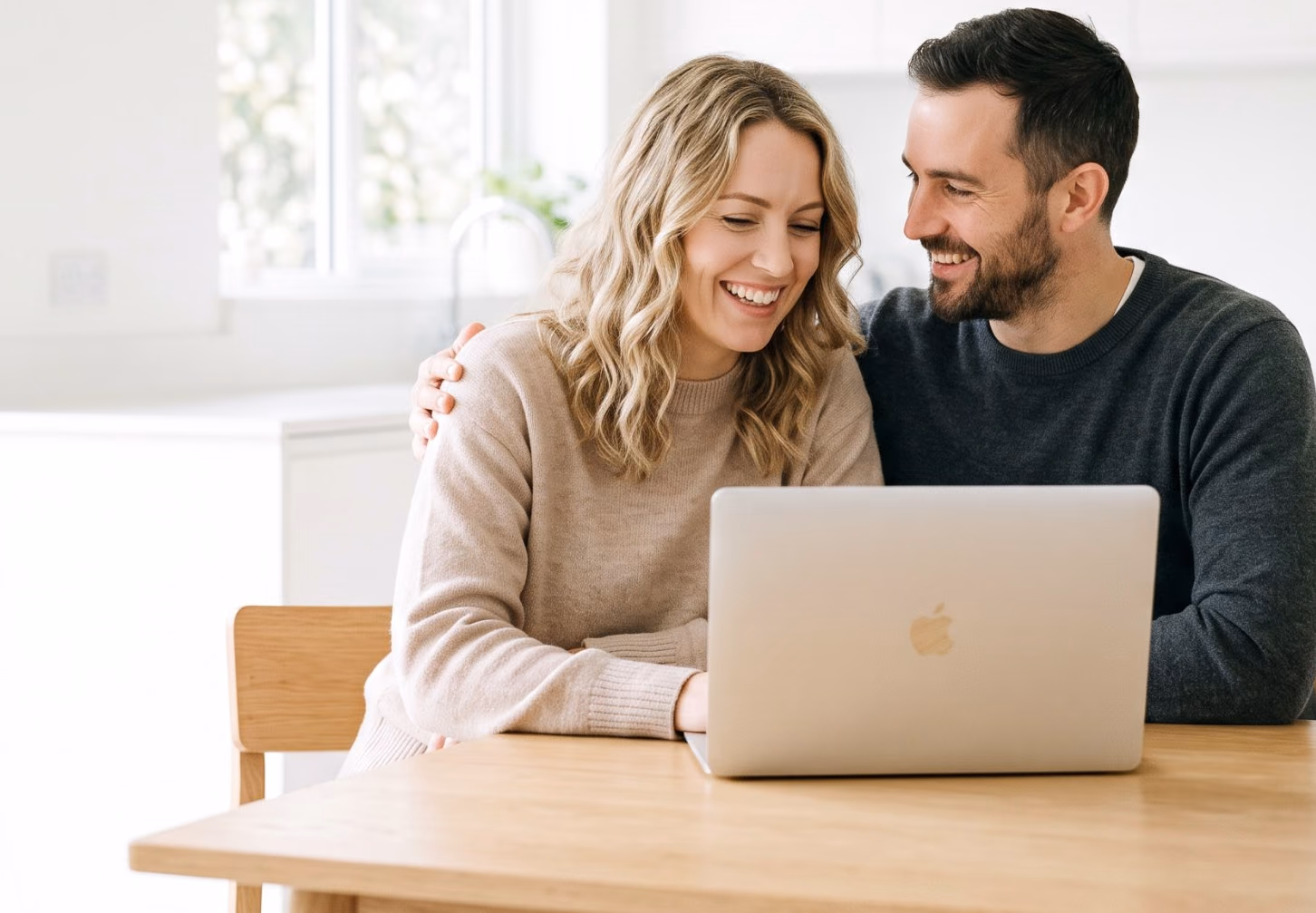 Couple smiling at a laptop